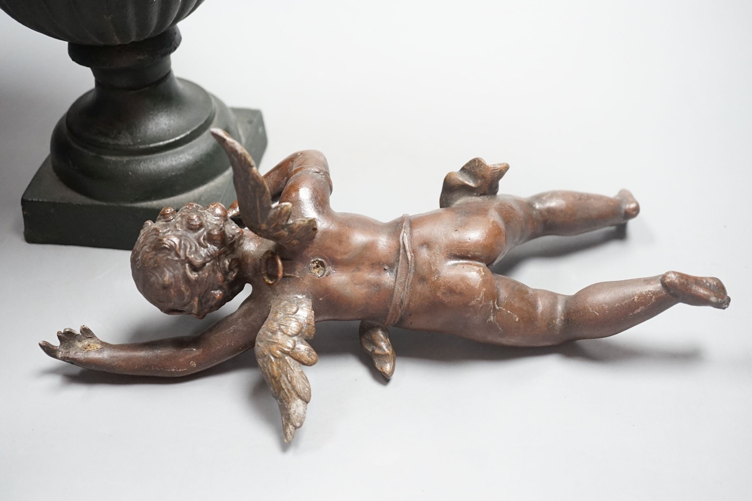 A bronzed cherub figure and a cast iron urn- 27cms high.
